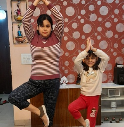 A person and a child doing yoga indoors